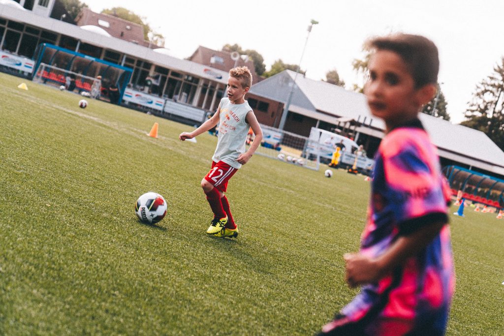 Deze 2 kinderen zijn heerlijk aan het voetballen. Door sponsor te worden helpt u hierbij.