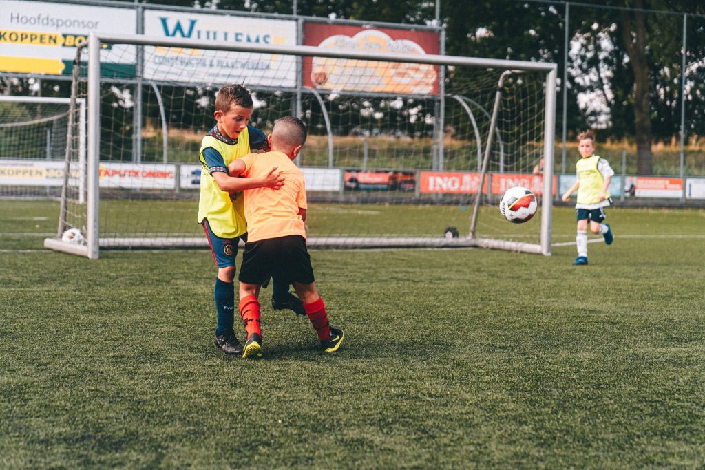 Kinderen trainen op het voetbalveld. 